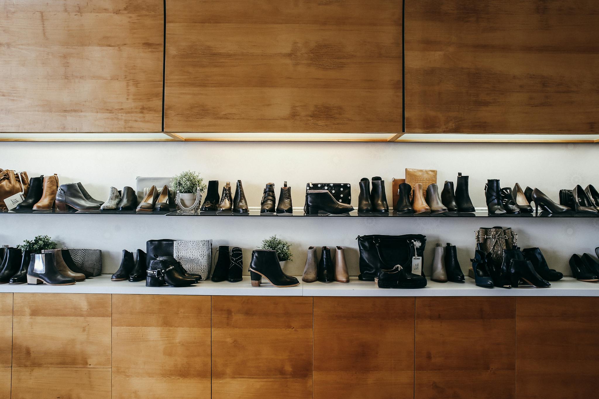 A stylish display of various shoes on wooden shelves in a modern boutique setting.